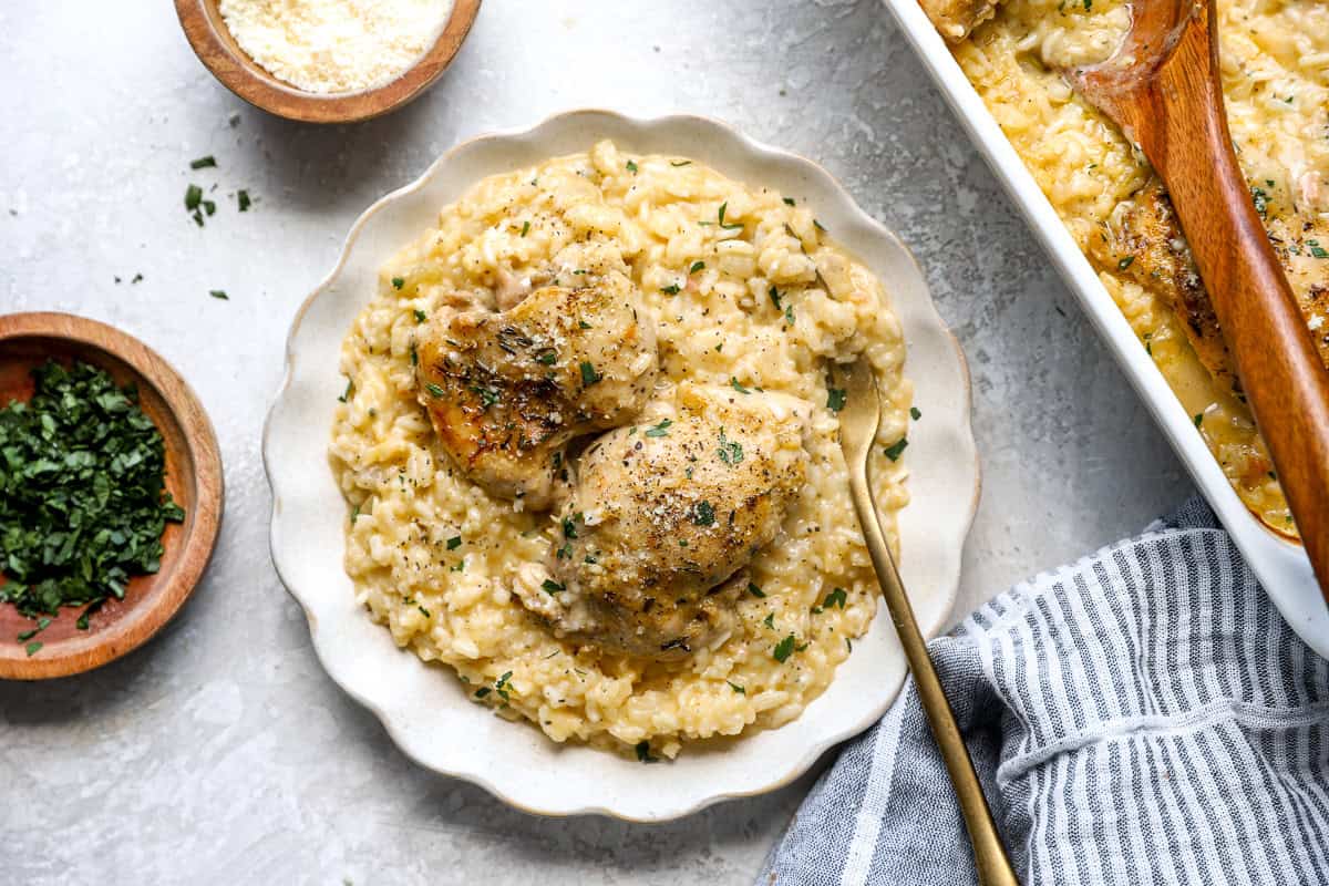 A serving of baked chicken thighs and creamy rice on a plate.