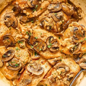 Close-up of creamy chicken diane with mushrooms and garnished with parsley.