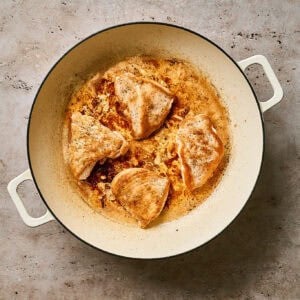 Seared chicken cutlets in a skillet.