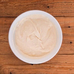 Dressing for chicken macaroni salad in a small white bowl.