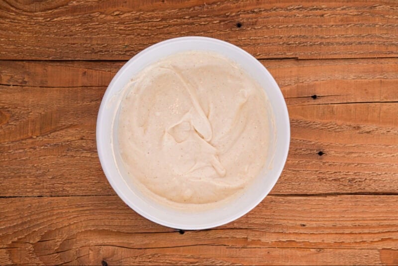 Dressing for chicken macaroni salad in a small white bowl.