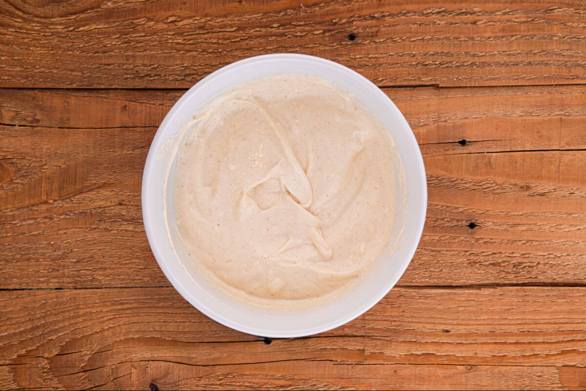 Dressing for chicken macaroni salad in a small white bowl.