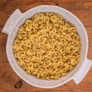 Cooked elbow macaroni in a large white bowl.