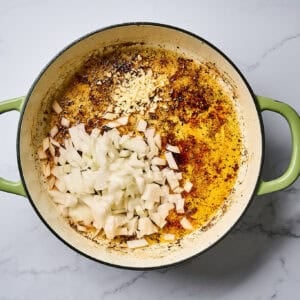 Onion and garlic in a skillet with rendered chicken fat.