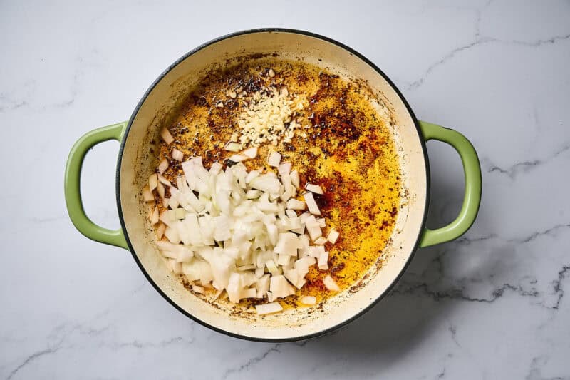 Onion and garlic in a skillet with rendered chicken fat.