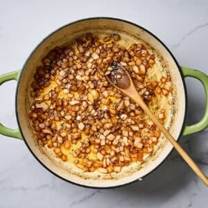 Sautéed onion and garlic in a skillet over a white marble surface.
