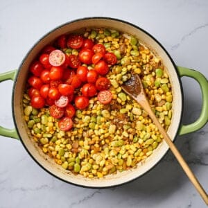 Fresh cherry tomatoes in a skillet of corn and lima beans.