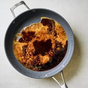Soy sauce and brown sugar being heated in a skillet.