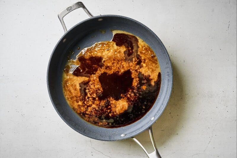 Soy sauce and brown sugar being heated in a skillet.
