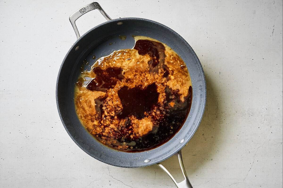 Soy sauce and brown sugar being heated in a skillet.
