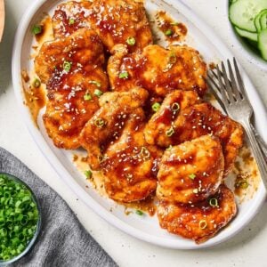 Shoyu chicken garnished with sesame seeds and sliced green onions.
