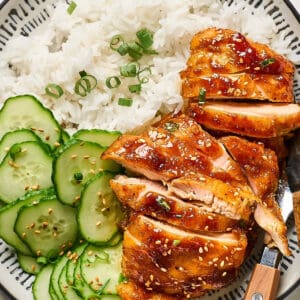 Shoyu chicken served with rice and sliced cucumber.