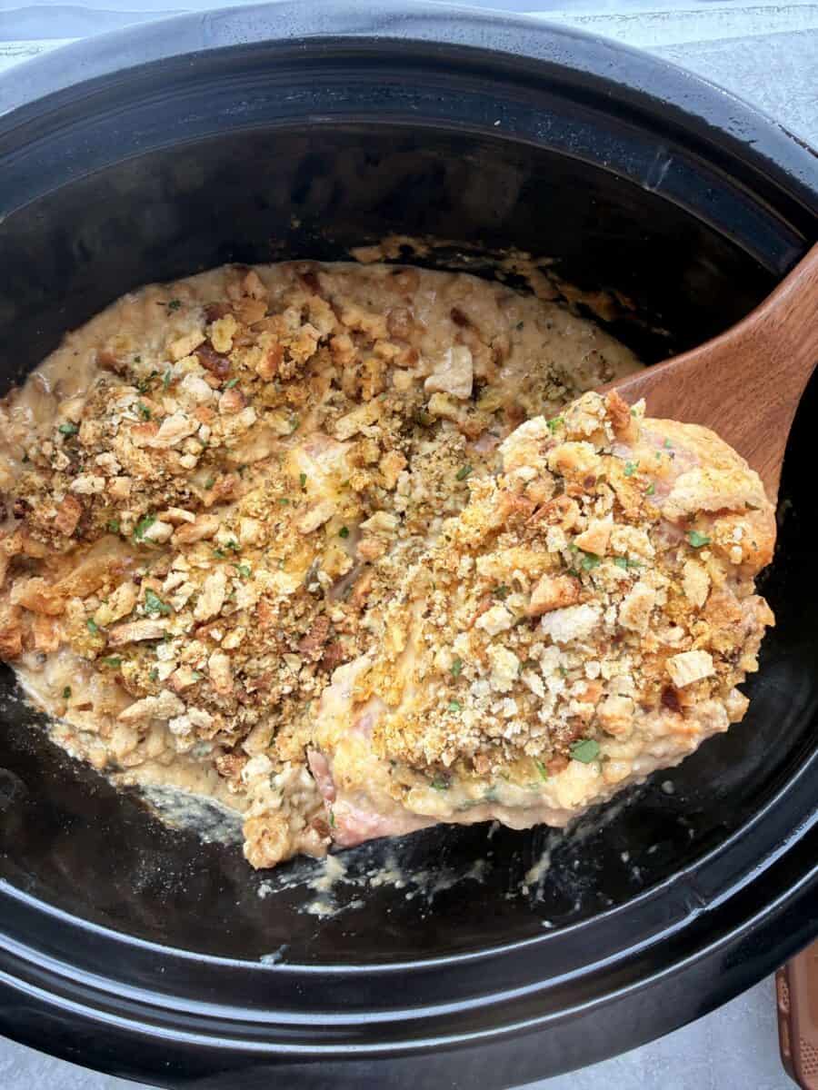 Lifting chicken cordon bleu out of a slow cooker.