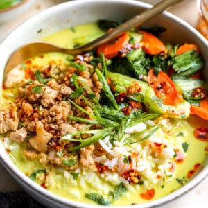 Ginger coconut broth soup filled with rice, ground chicken, carrots, and bok chow,