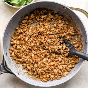 Browned ground chicken in a skillet.