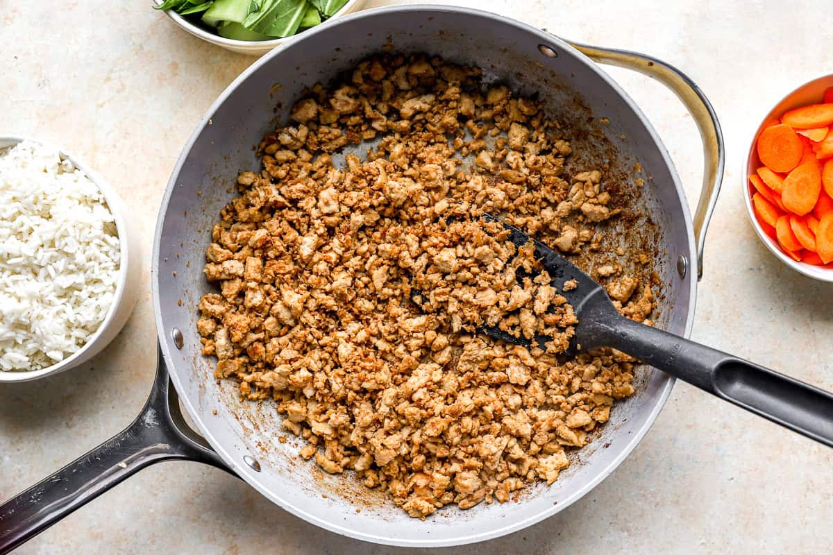 Browned ground chicken in a skillet.