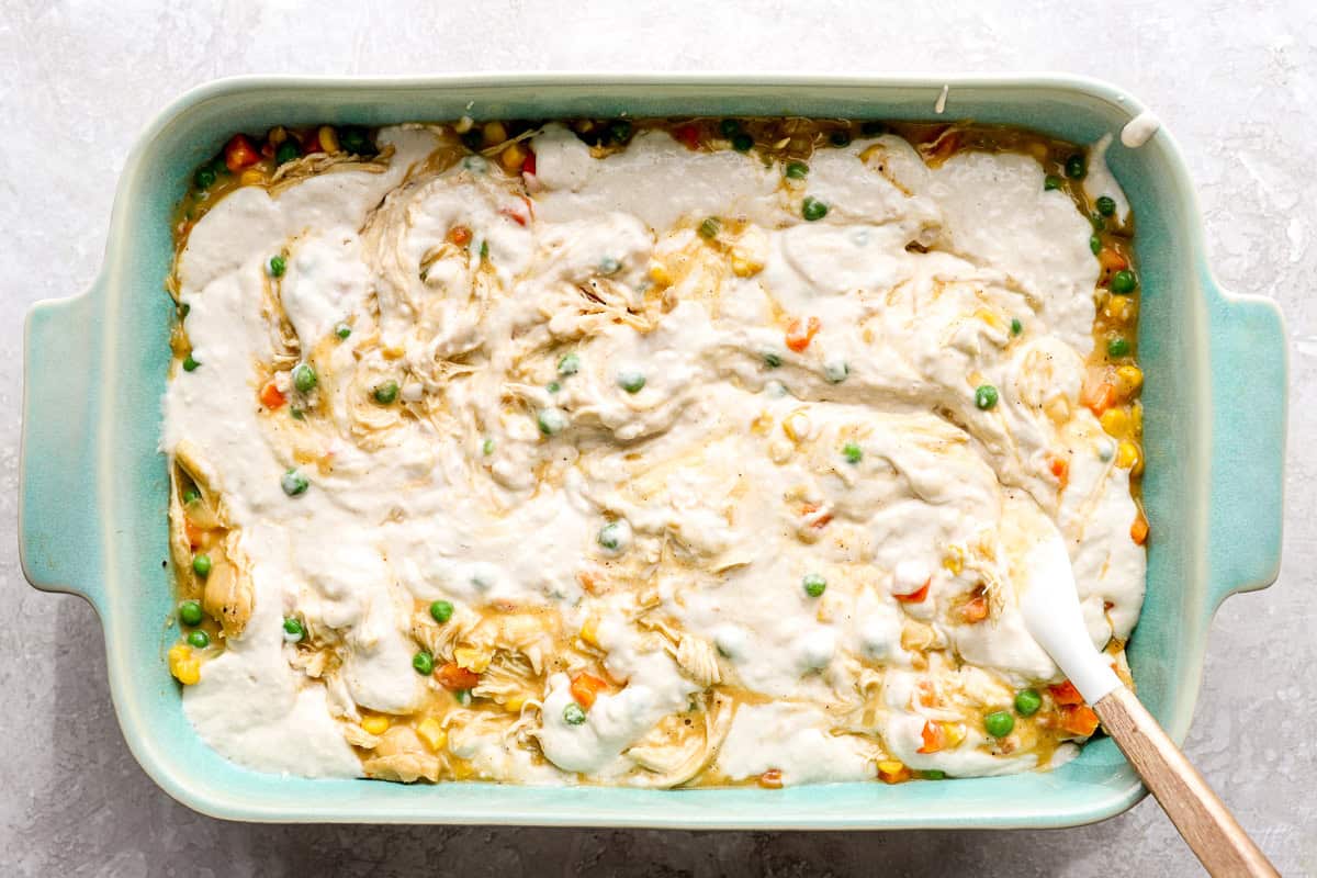 Swirled biscuit batter over chicken cobbler.