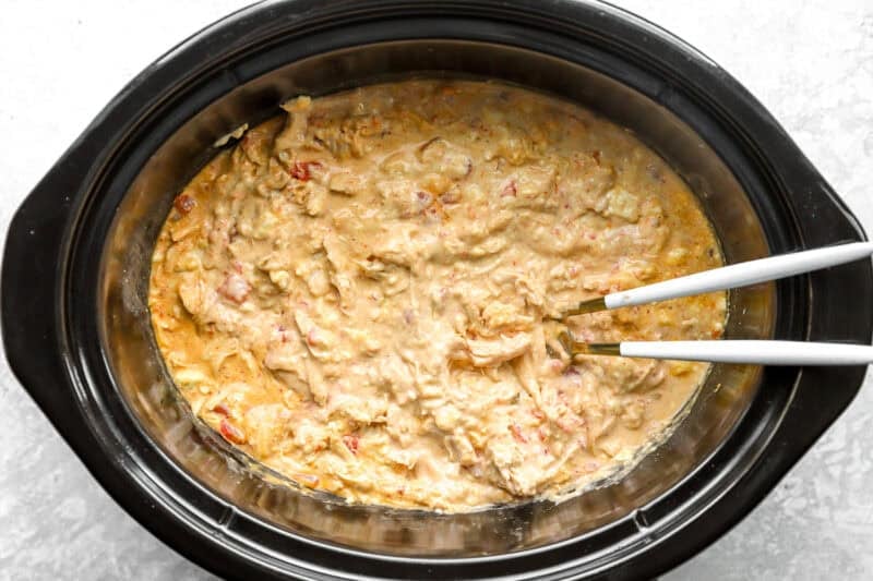 Finished queso chicken in a slow cooker.