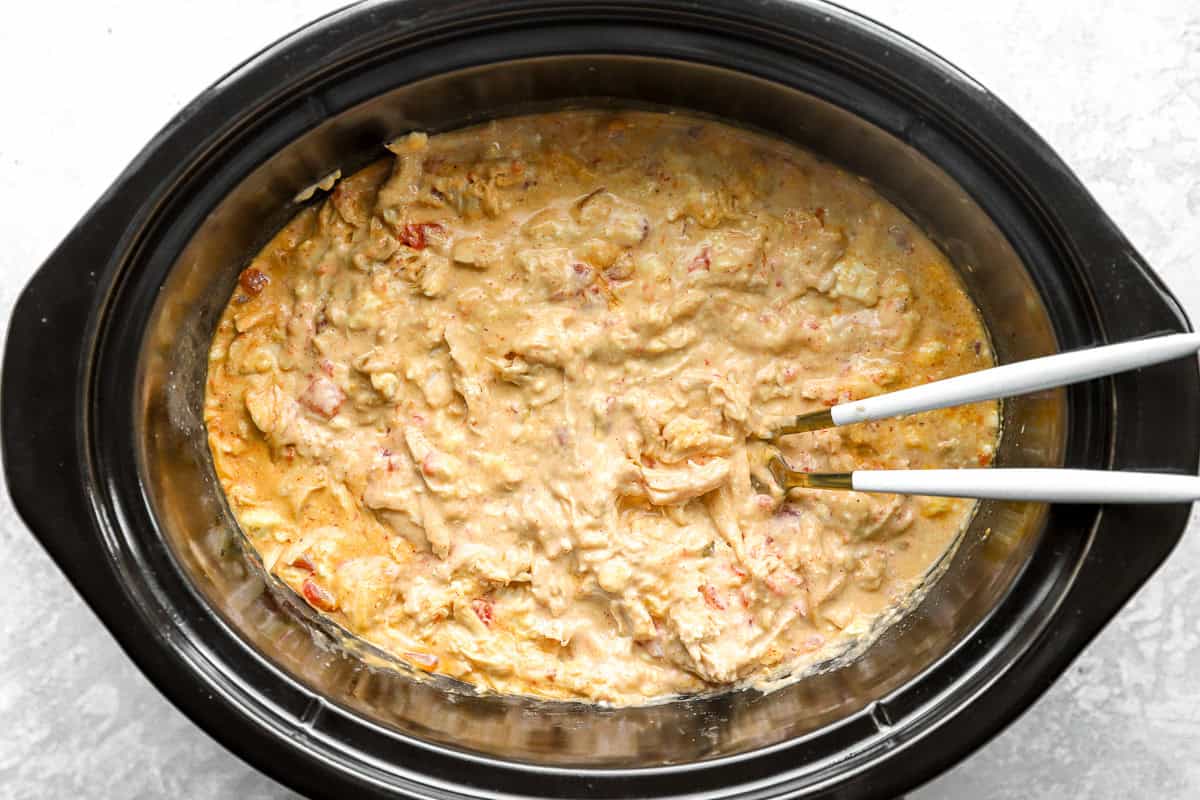 Finished queso chicken in a slow cooker.