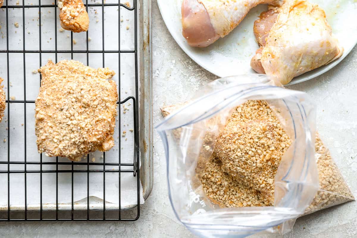 Dredging chicken in seasoned breadcrumbs.