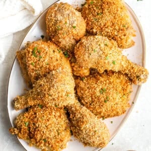 A platter of breaded baked chicken legs.