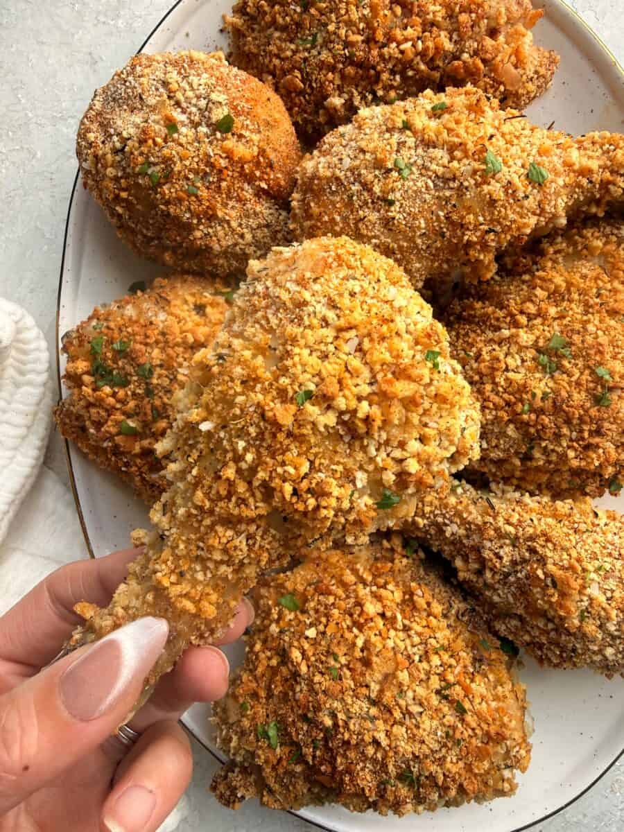 Holding up a drumstick to show the crispy crunchy Shake n' Bake breading.