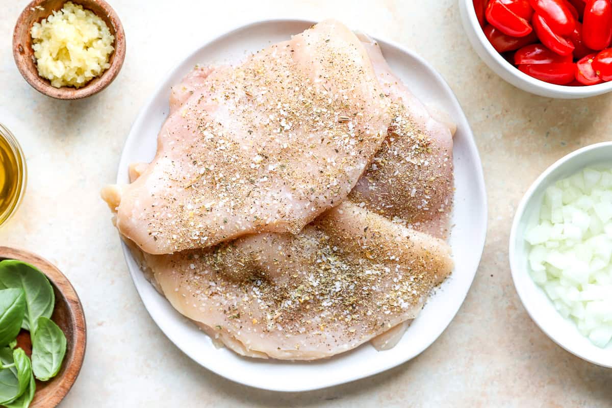 Raw seasoned chicken breasts.