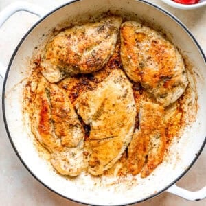 Browned chicken breasts in a pan.