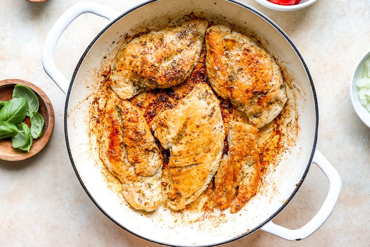 Browned chicken breasts in a pan.