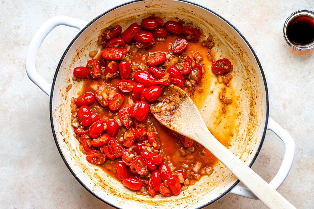 Cooking grape tomatoes in a pan.