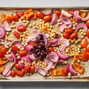 Kalamata olive added to the sheet pan with chickpeas and veggies.