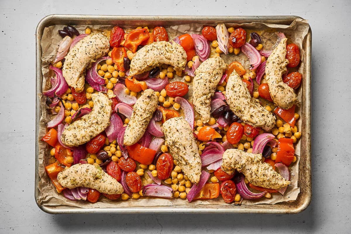 Greek chicken and vegetables in a sheet pan, after roasting.
