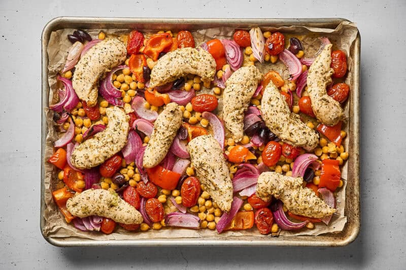 Greek chicken and vegetables in a sheet pan, after roasting.