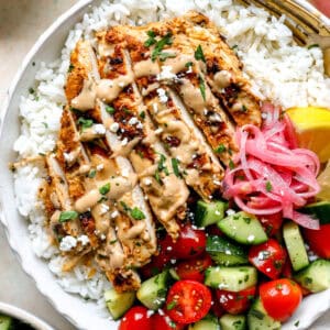 Grilled tahini chicken sliced and served in a bowl of rice and veggies.