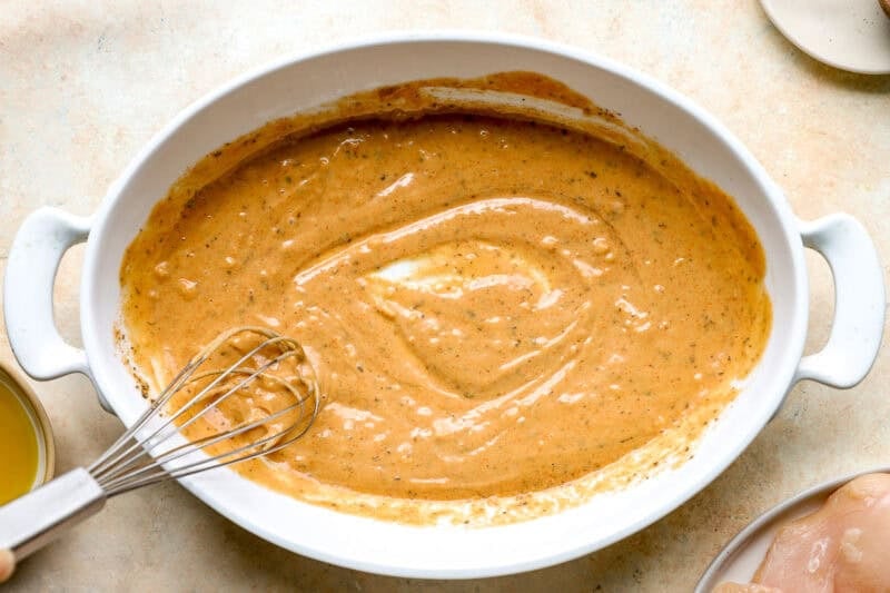 Whisking together a homemade tahini sauce.