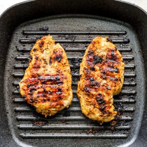 Cooked chicken breasts on a grill pan.