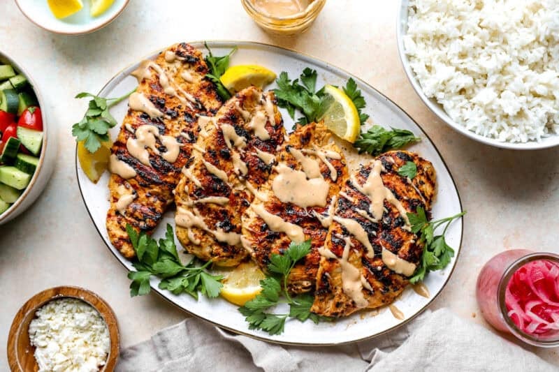 A plate of grilled chicken and tahini sauce.