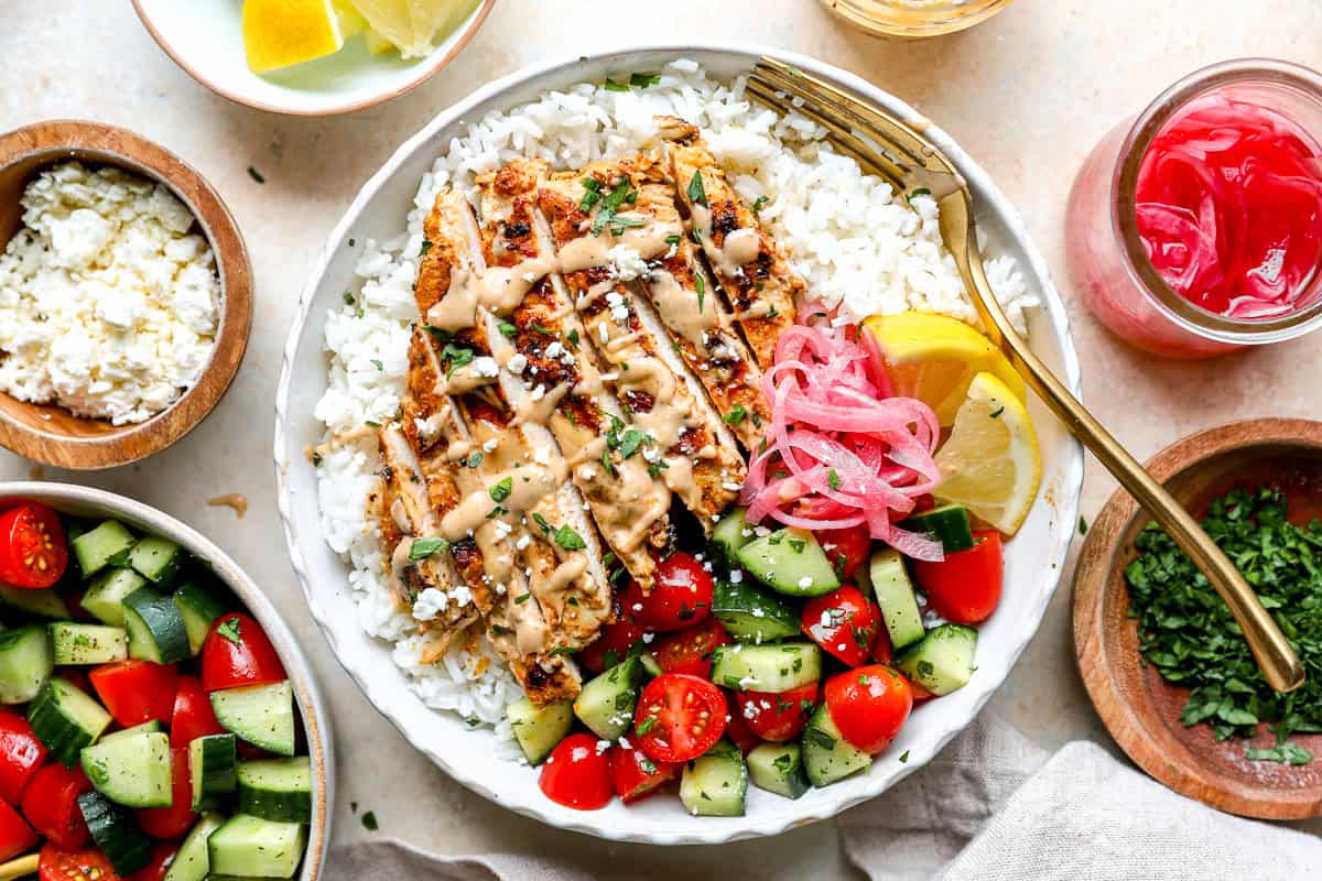 Tahini chicken served in a rice bowl, garnished with extra sauce.