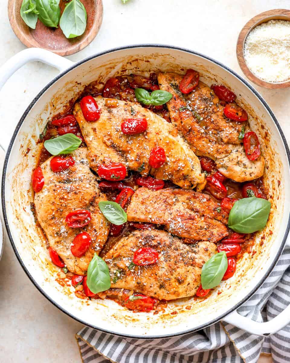 Tomato basil chicken breasts in a pan.