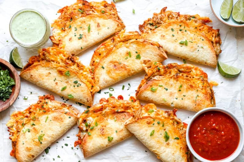Cheesy baked chicken tacos served with salsa and cilantro lime sauce.