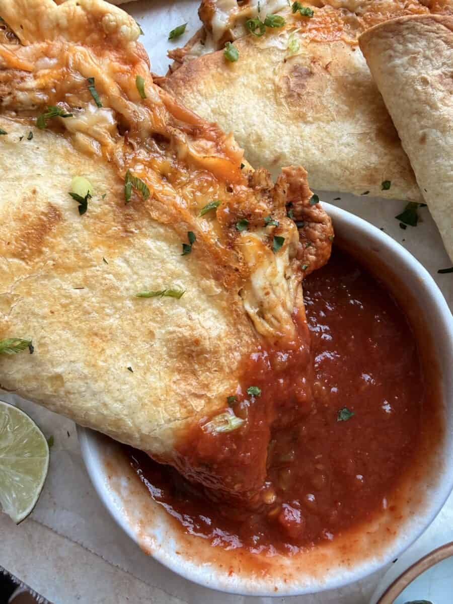 Dipping a baked chicken taco in salsa.