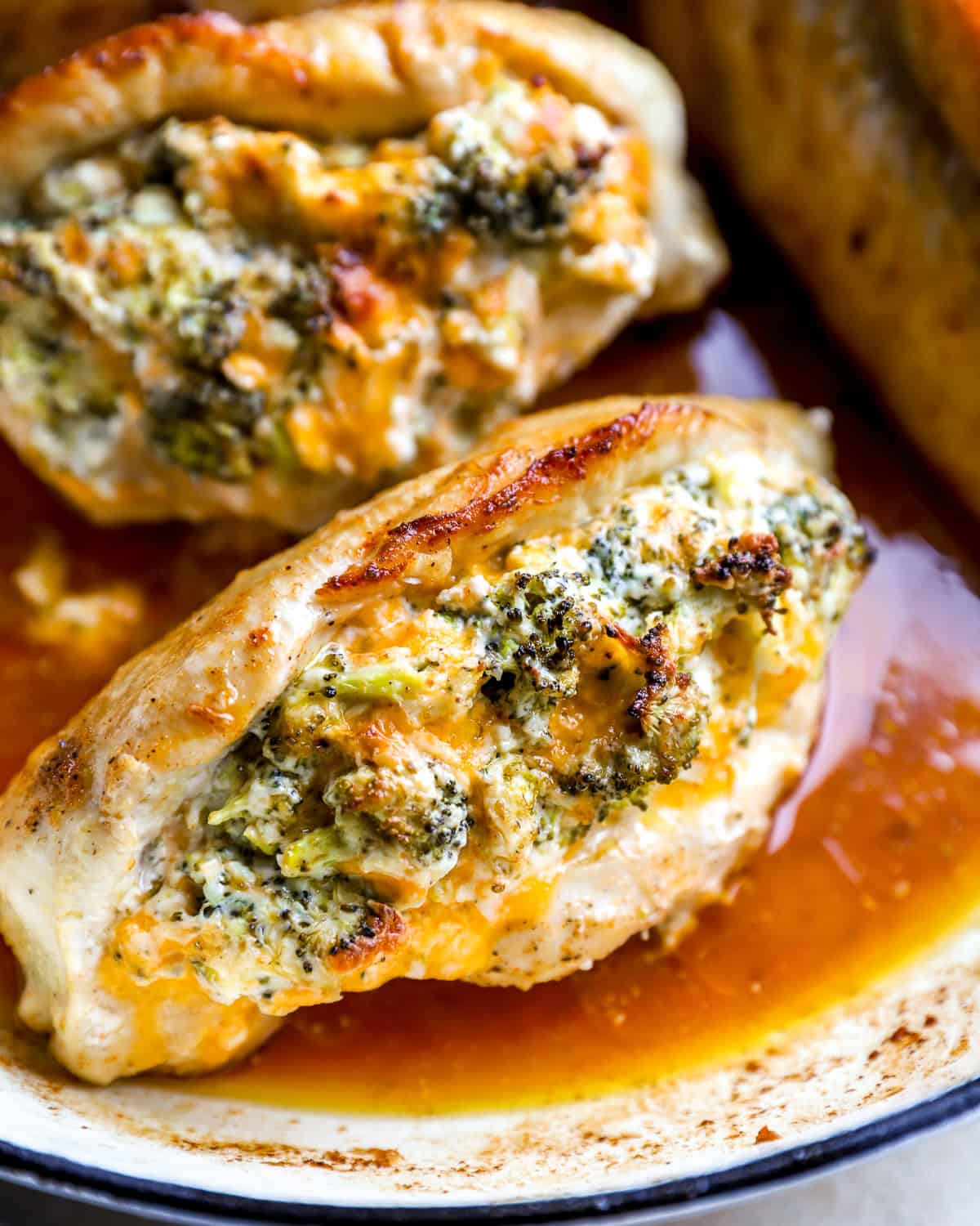 Broccoli and cheese stuffed chicken breasts in a pan.
