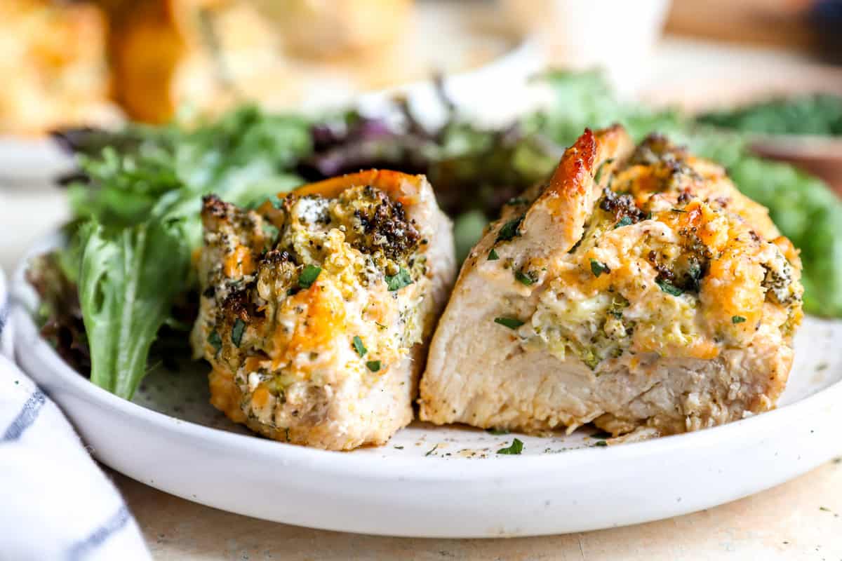 A serving of broccoli cheese stuffed chicken, sliced in half to show the filling.