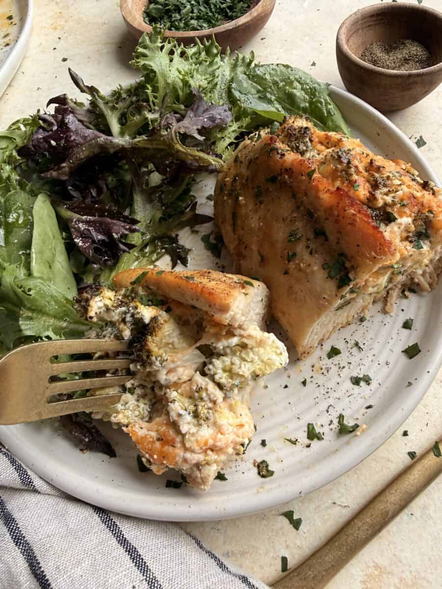 Eating a serving of stuffed chicken breasts.