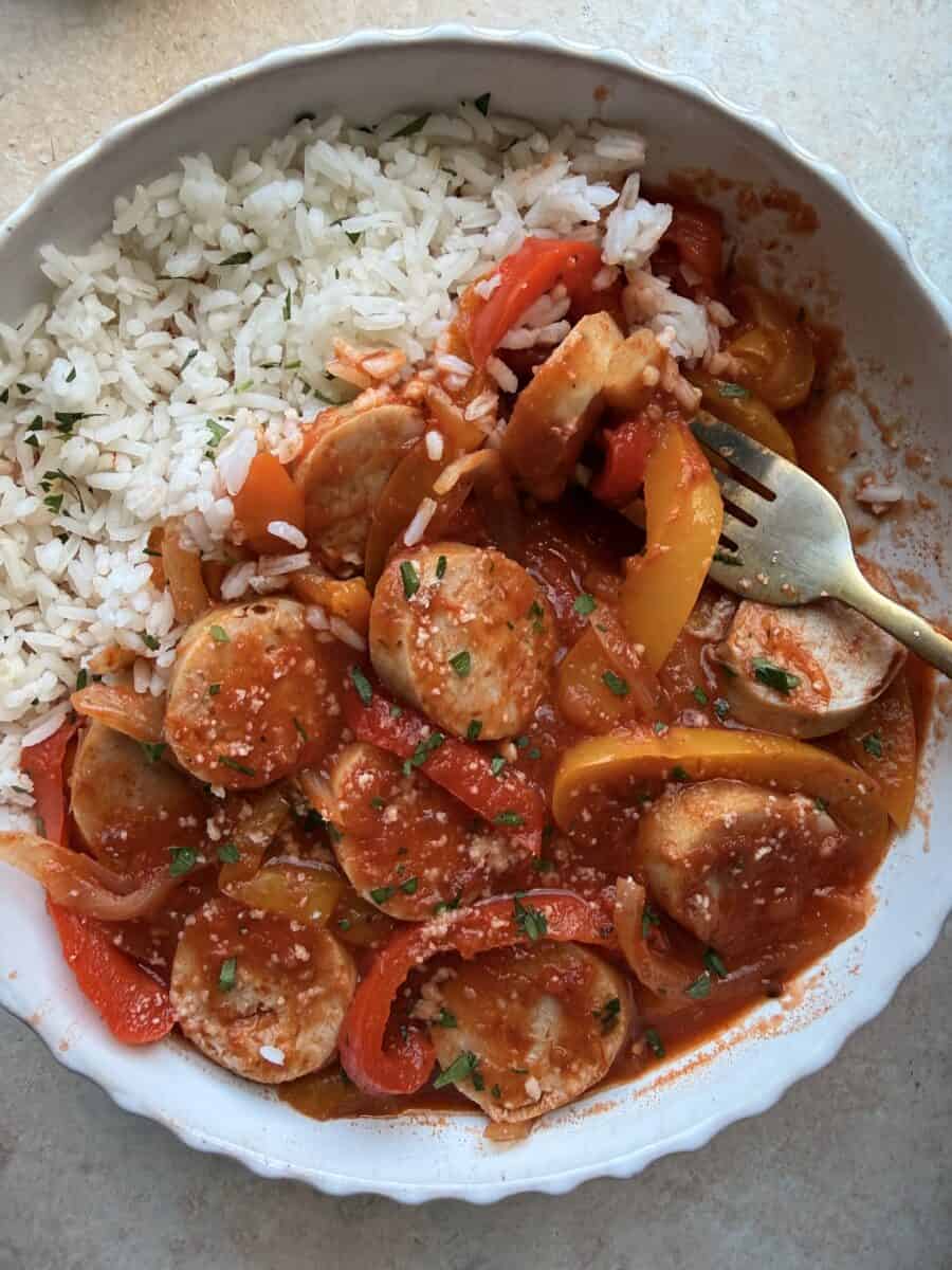 Eating a bowl of chicken sausage and peppers.