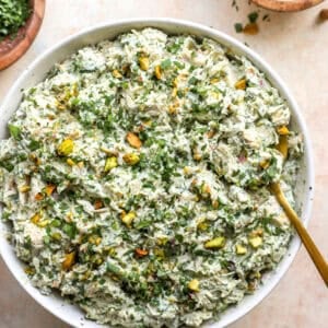 A bowl of green goddess chicken salad with pistachios.