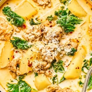 Close up on a bowl of Zuppa Toscana soup, filled with ground chicken, potatoes, and kale.