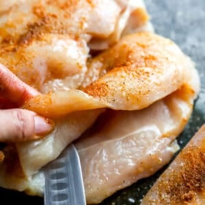 Cutting a pocket into the side of a chicken breast.