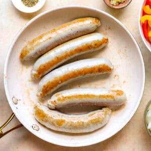 Italian chicken sausage cooking in a skillet.