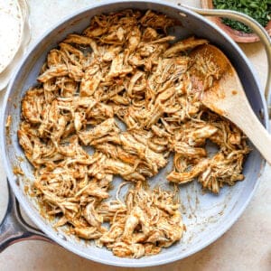 Cooking shredded chicken with taco seasoning.